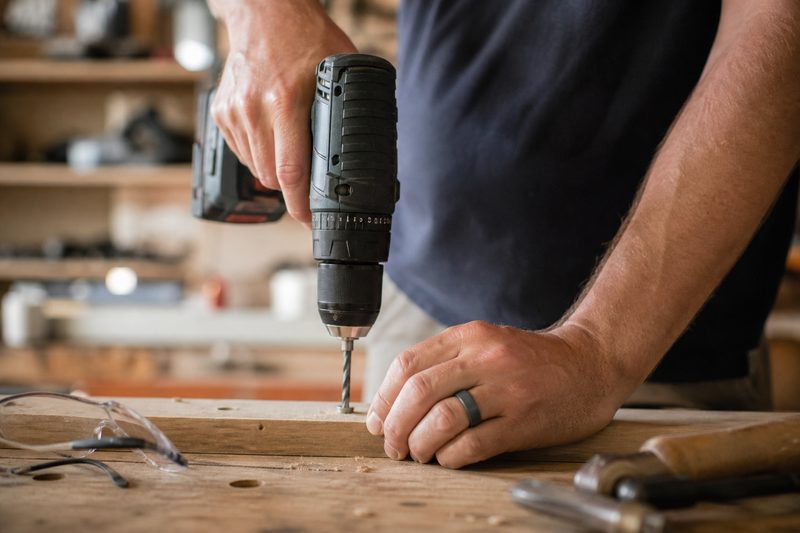 Tradesman using a power drill while wearing a flexible silicone ring